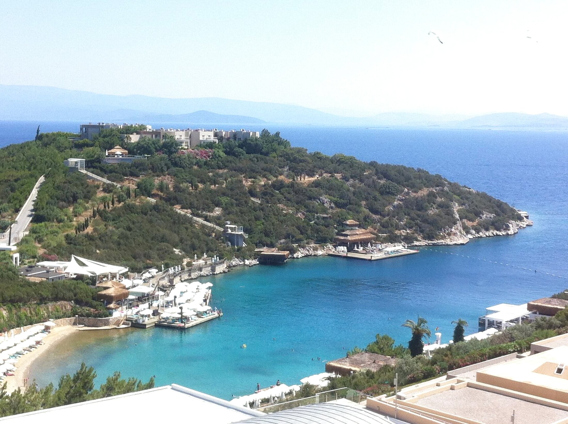 A turquoise cove on the north coast of the Bodrum peninsula, with pine-covered hills and boats at anchor